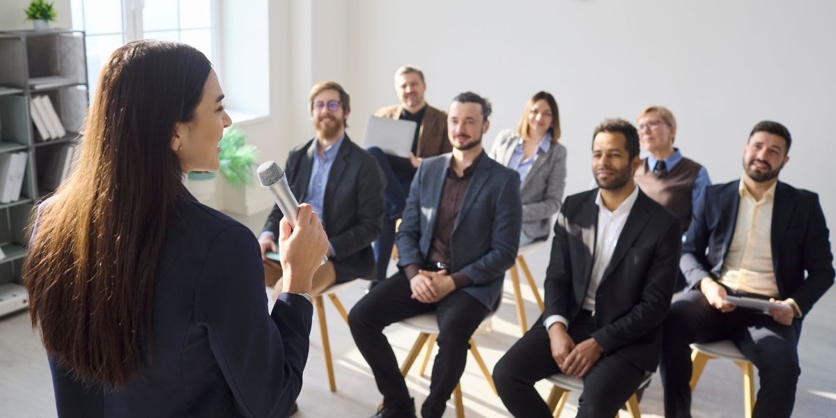 femme qui donne une formation devant des hommes assis