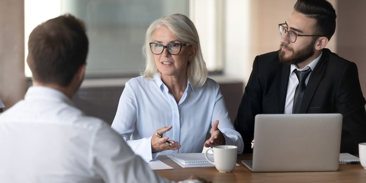 dame qui échange au travail avec deux hommes