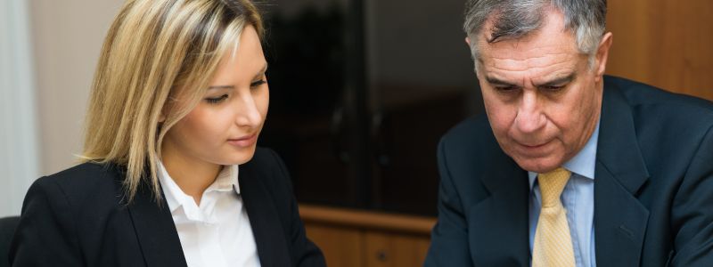 femme blonde à côté d'un homme au travail